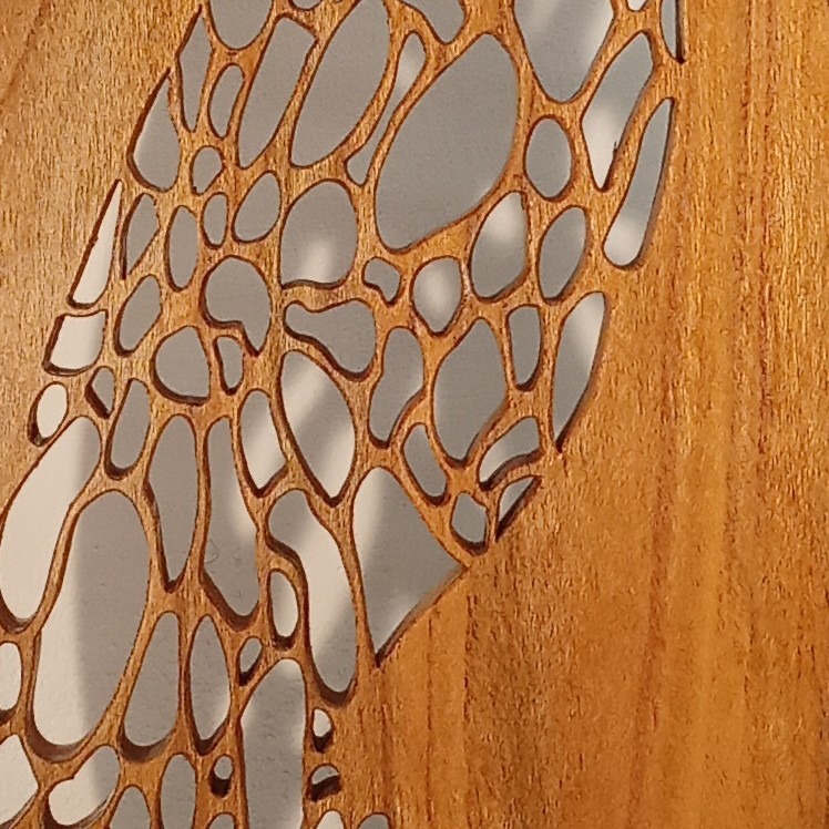 Détail de sculpture sur bois ajourée montrant la finesse des découpes artisanales réalisées à l’atelier Tutti Colori en Aveyron (Occitanie)