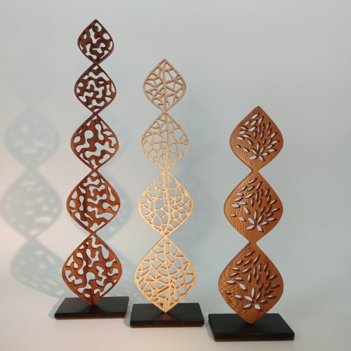 Sculptures en dentelle de bois aux formes verticales et ajourées, collection Sylence, posées sur socle